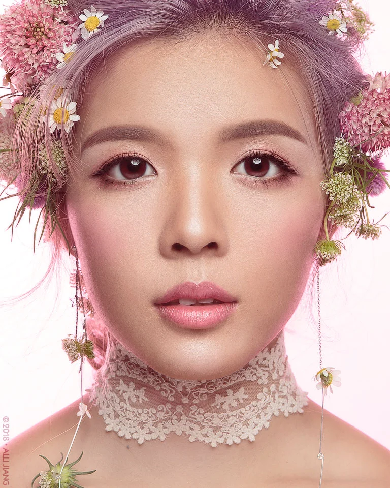 Beauty portrait with a floral headpiece in soft pink light
