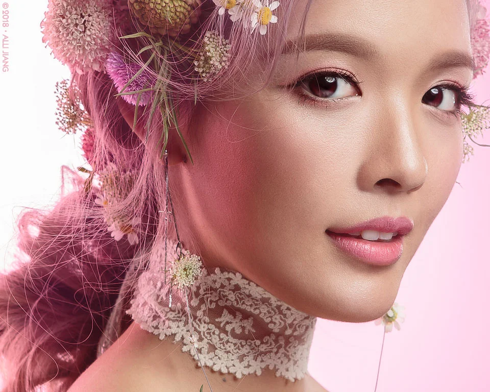 Close-up beauty portrait with pink florals and an antique lace choker