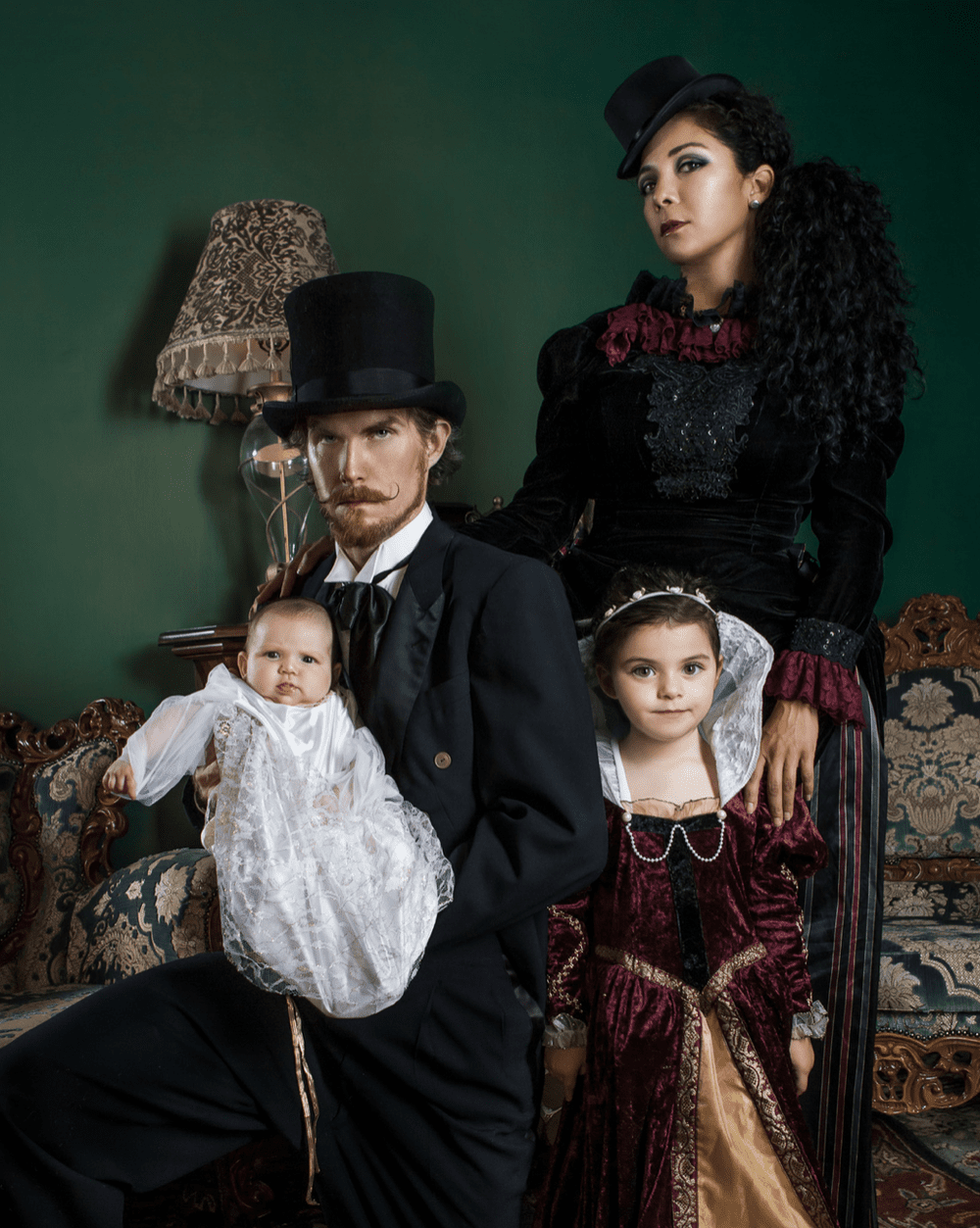 Victorian-style studio family portrait with a painted backdrop and constructed light.
