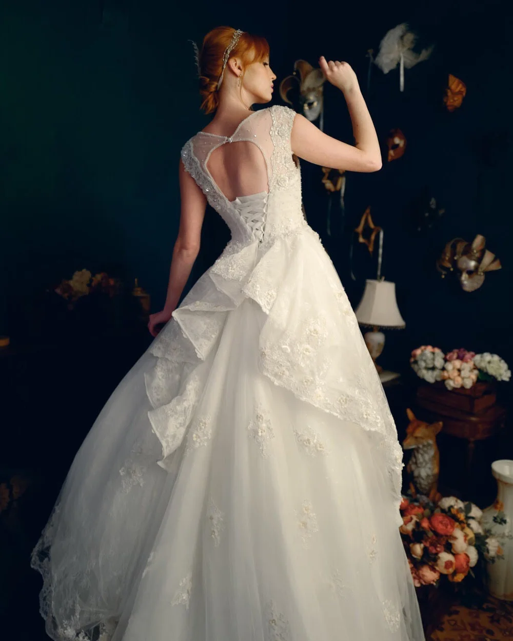 Bride in a full ballgown turning away from camera, framed by flowers