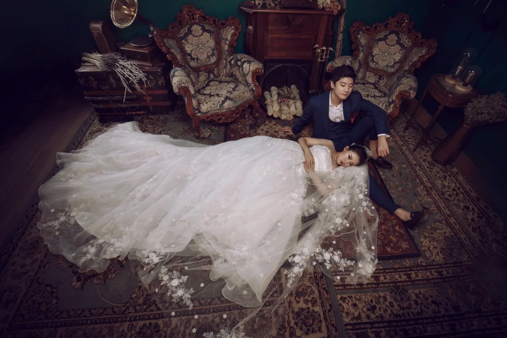 Painterly studio portrait of a couple in period costume on a Persian rug
