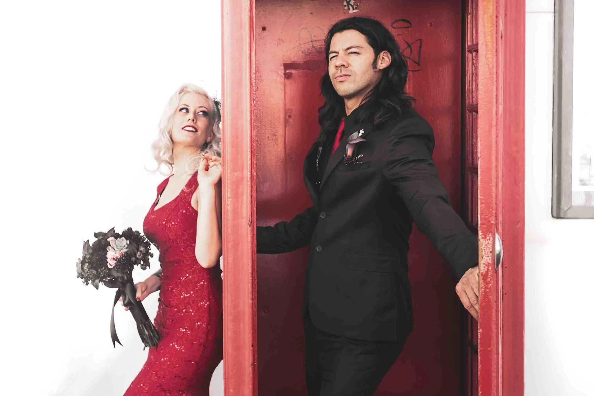 Couple photographed against a bright red door on a quiet Los Angeles side street