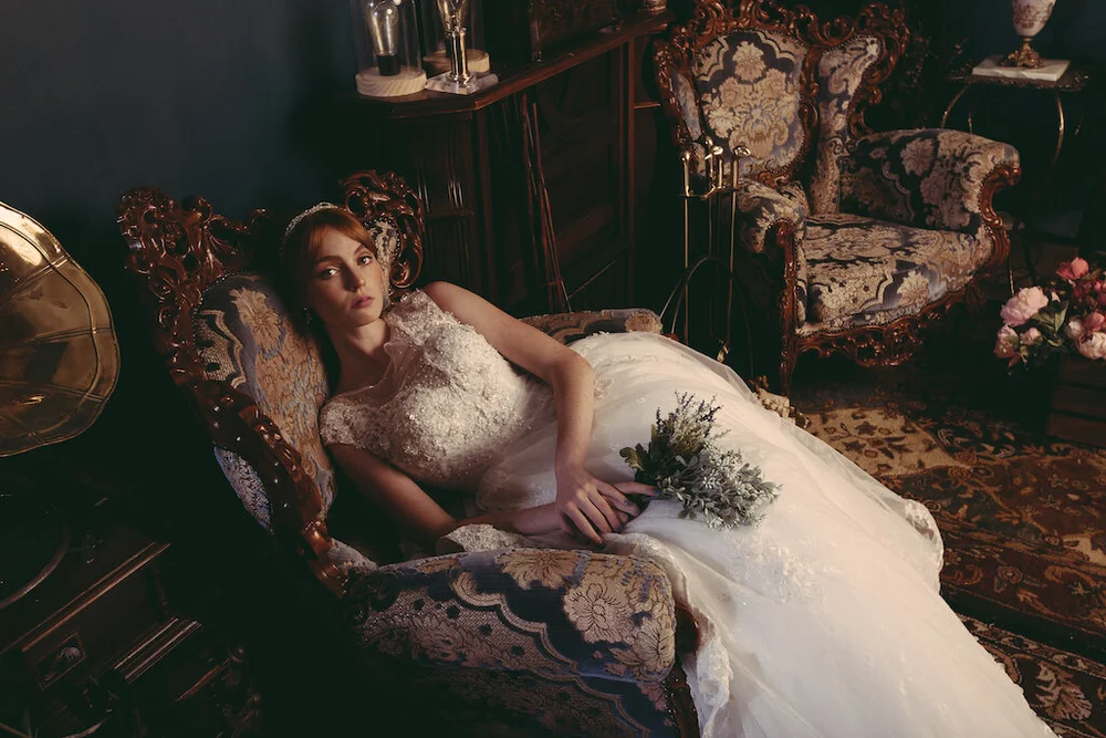 Bride photographed on an antique chaise in the studio's vintage set