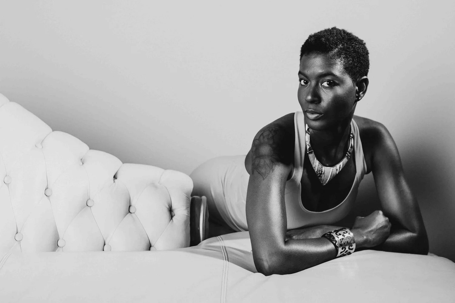 Black and white fashion portrait on a white tufted sofa, photographed in the Los Angeles studio