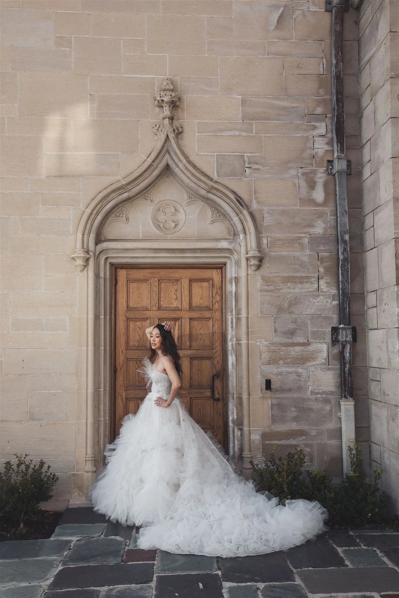 Bride framed by the stone arch at Greystone Mansion, Beverly Hills