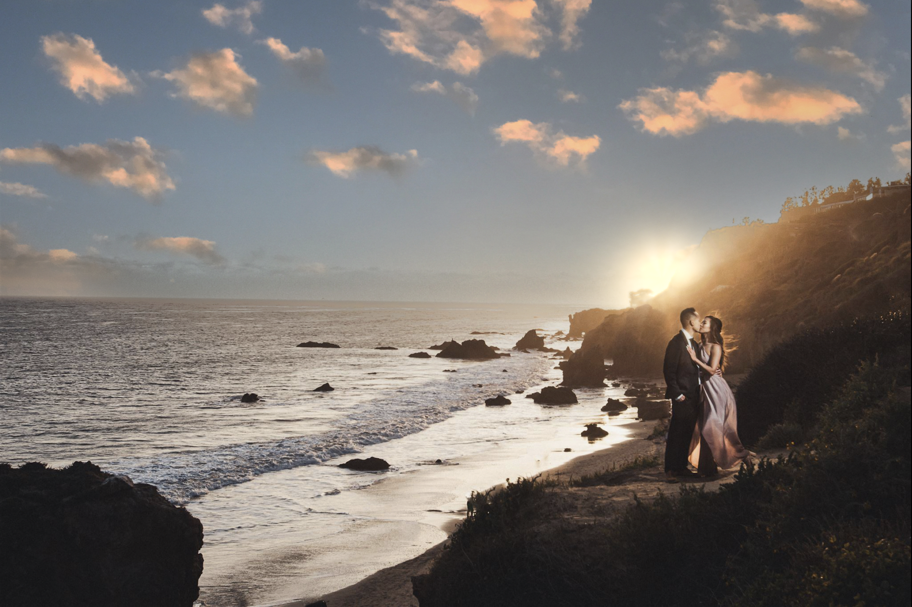 Engaged couple on the cliffs above El Matador State Beach in Malibu at sunset