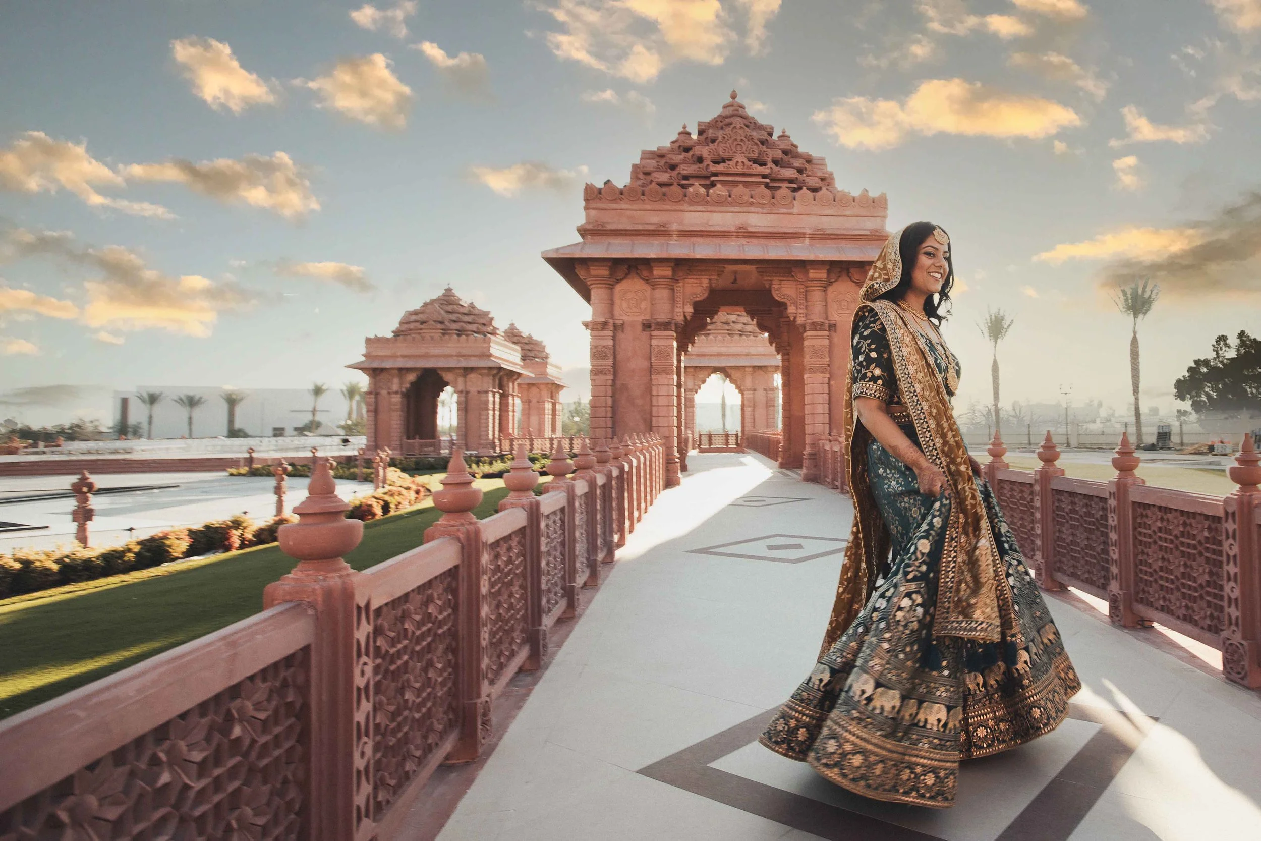 Indian bride in a lehenga at the BAPS Shri Swaminarayan Mandir at sunset, photographed by Lulan Studio