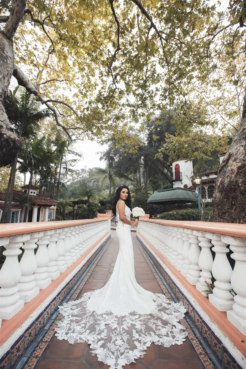 Bride at the top of a tiled staircase, lace train cascading down the steps