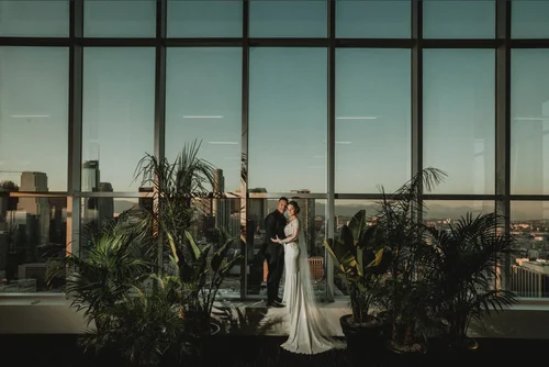 Couple photographed inside a glass conservatory full of tropical plants