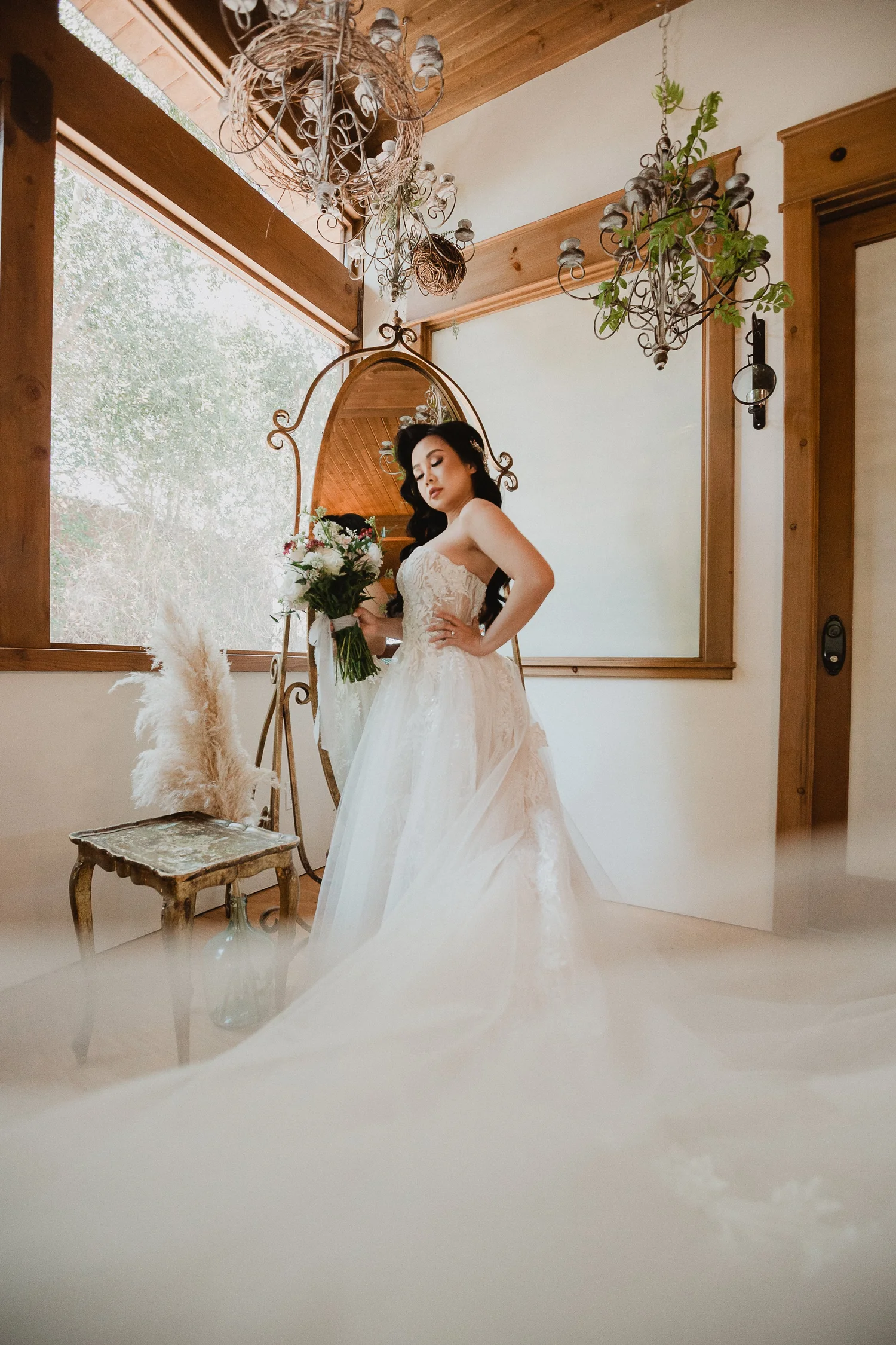 Bride in a strapless tulle ballerina gown in a sunlit bridal suite with an arched gilt mirror