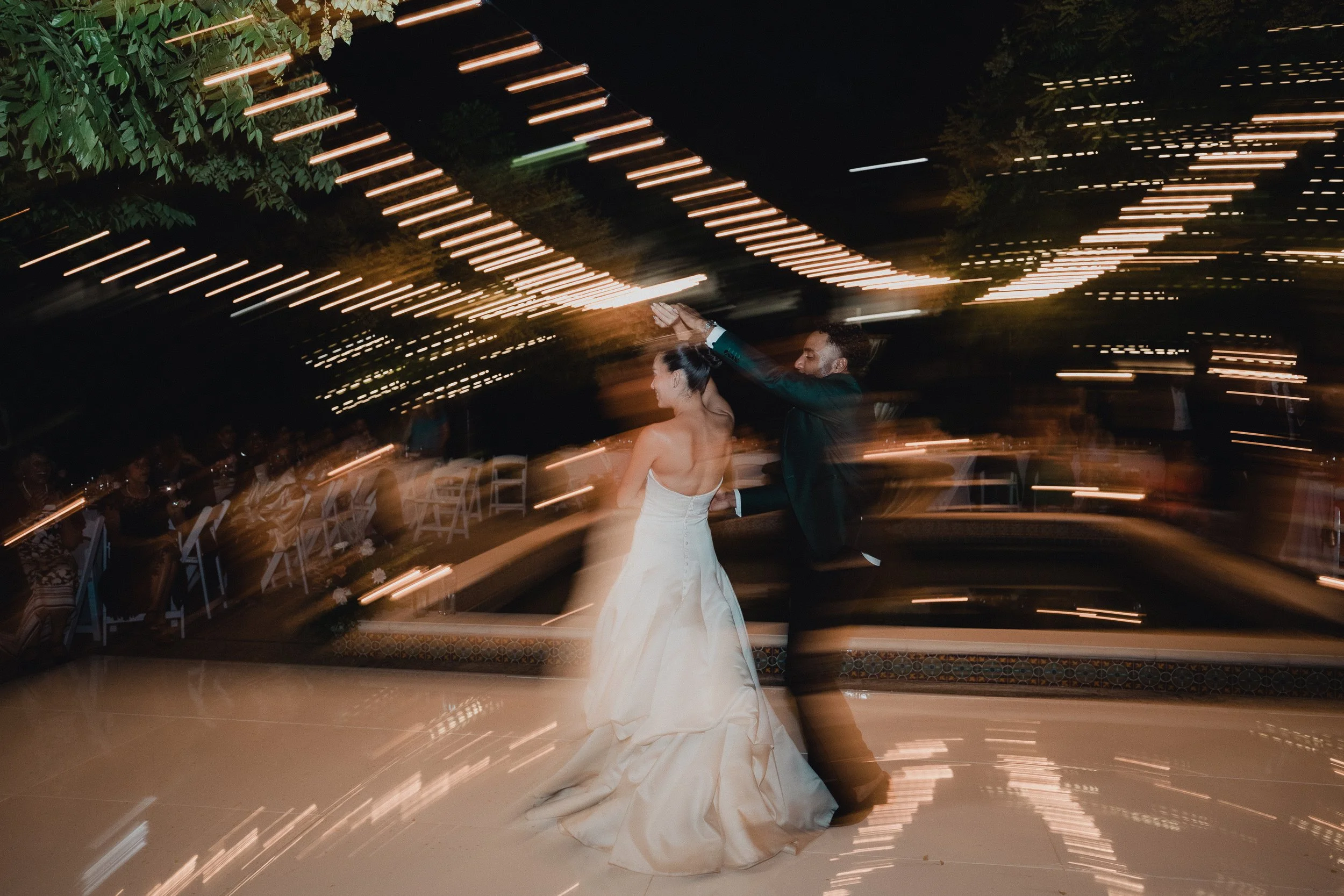 Newlyweds dancing under string lights at their Los Angeles garden wedding reception, photographed by Lulan Studio