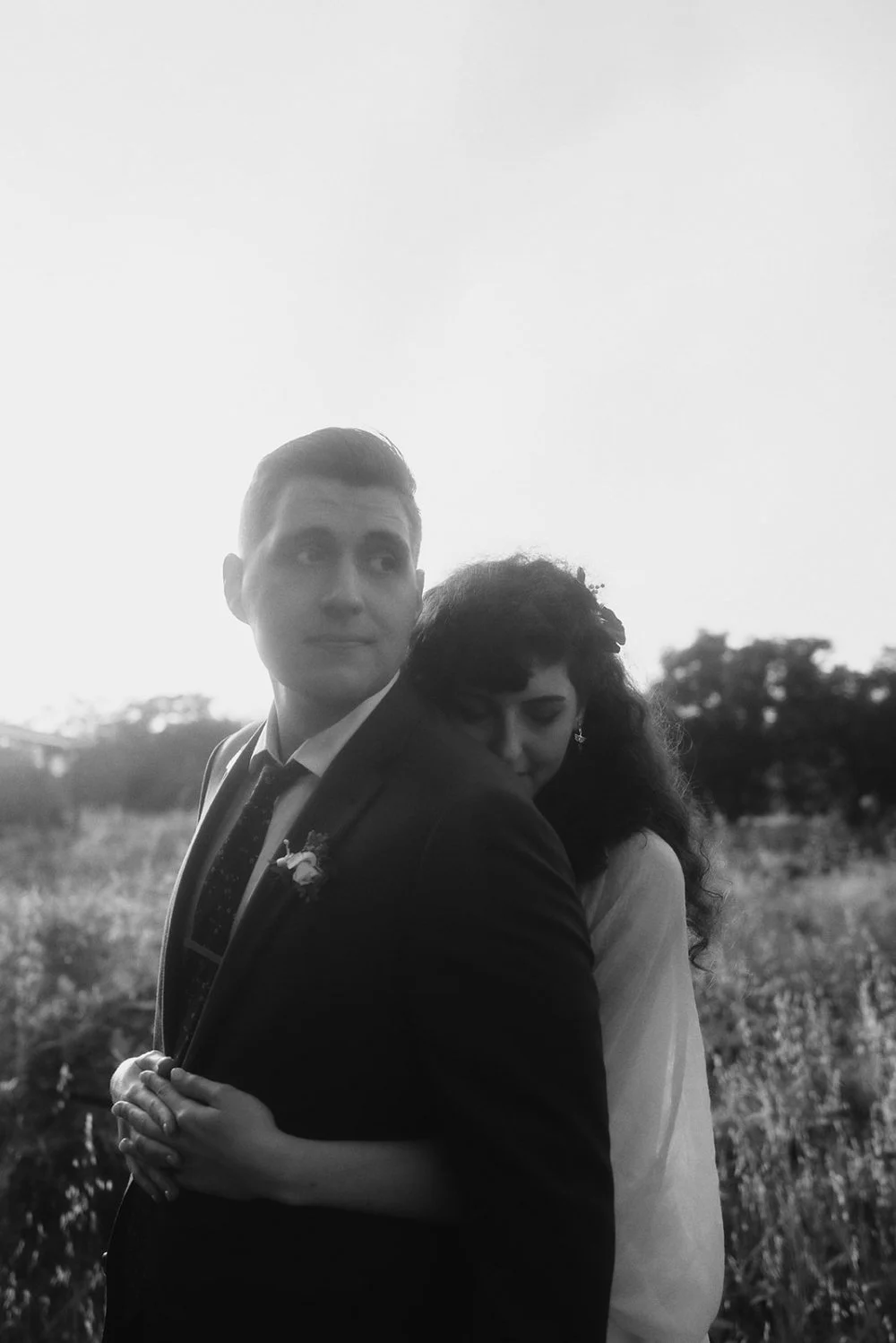Couple standing close together in a dry summer field