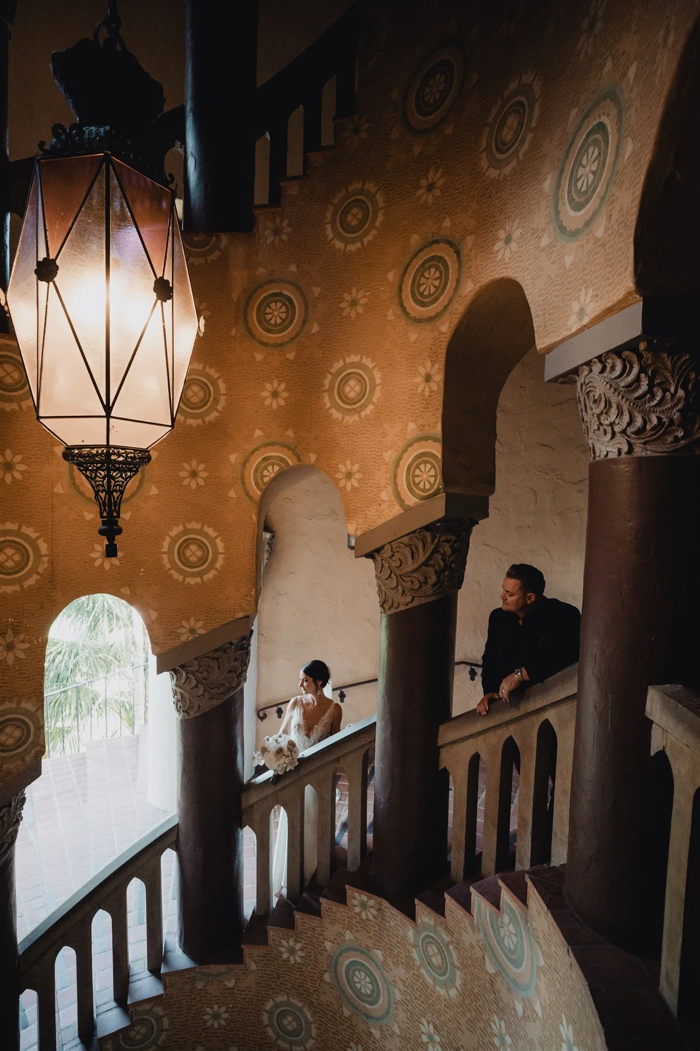 Couple on the balcony of the arched loggia beneath the painted ceiling of the Santa Barbara County Courthouse