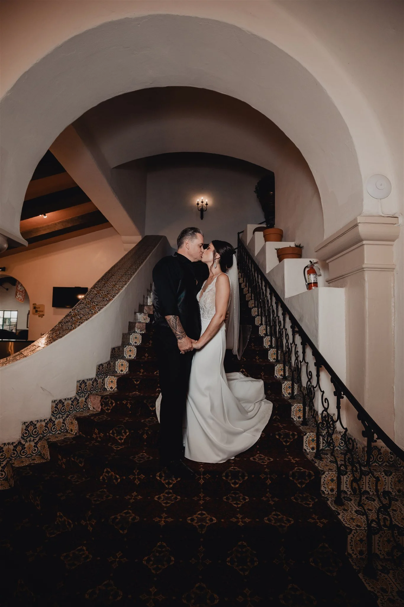 Bride and groom on the sweeping staircase under the great arch of the Santa Barbara County Courthouse
