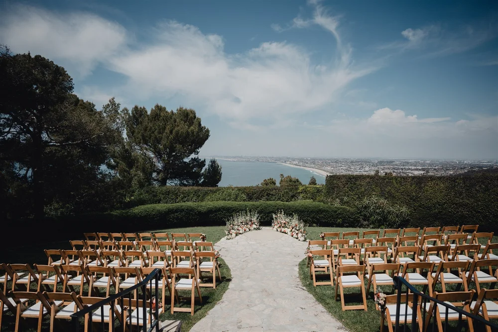 La Venta Inn ceremony lawn set with wooden chairs, Santa Monica Bay behind it
