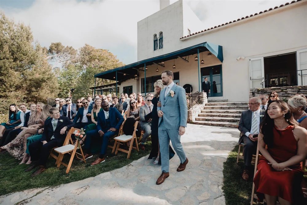 Groom walking the aisle past guests in front of the La Venta Inn villa
