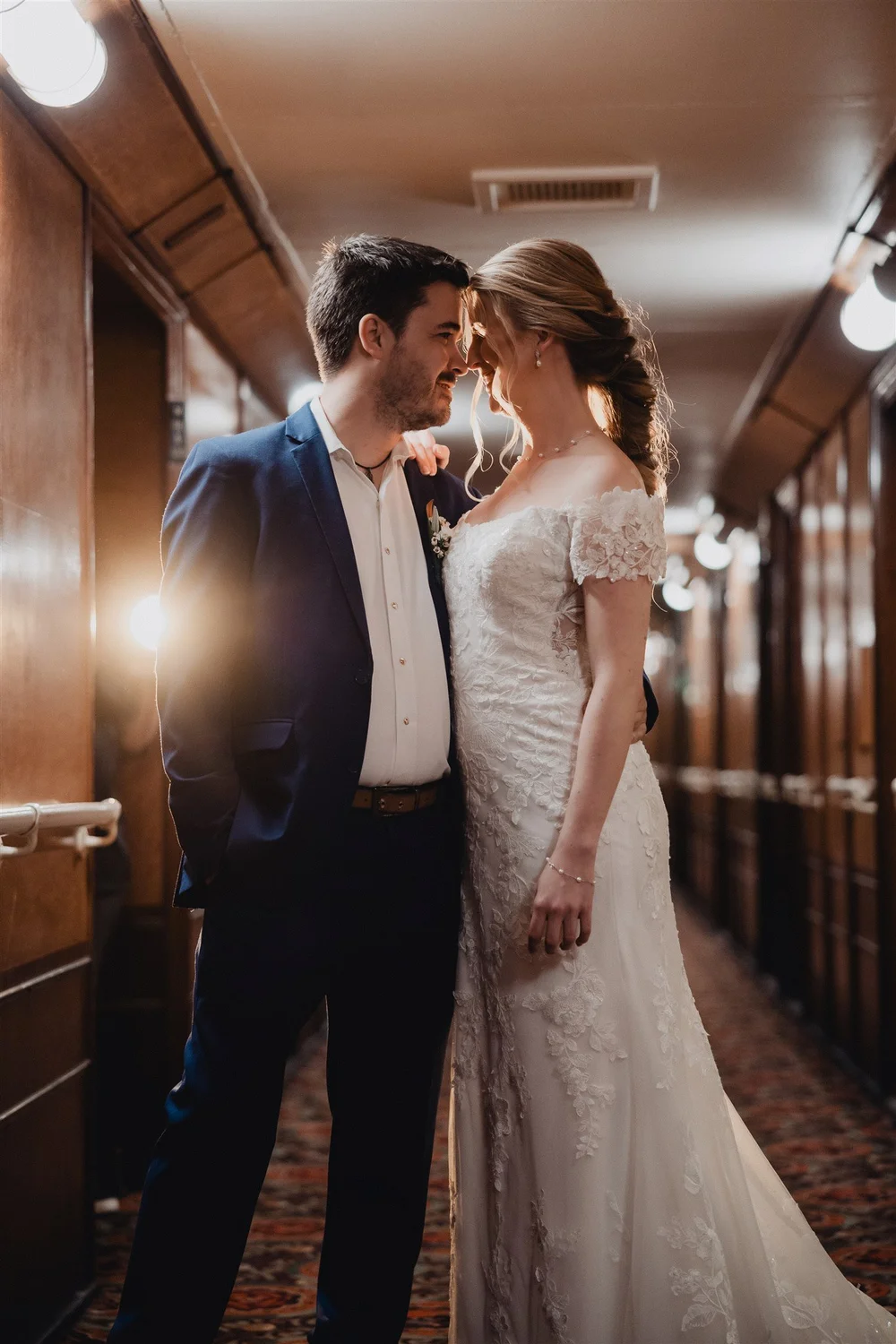 Couple nose to nose in a wood-panelled corridor aboard the Queen Mary