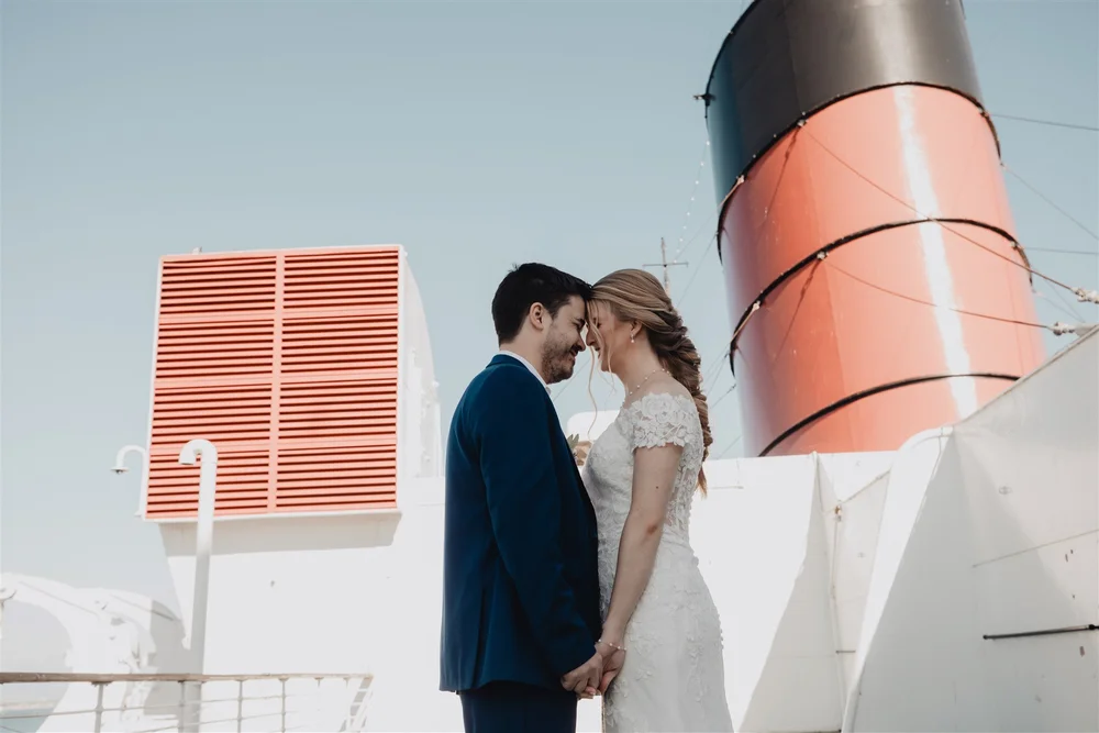 Couple beneath the Queen Mary’s red and black funnel on the sun deck