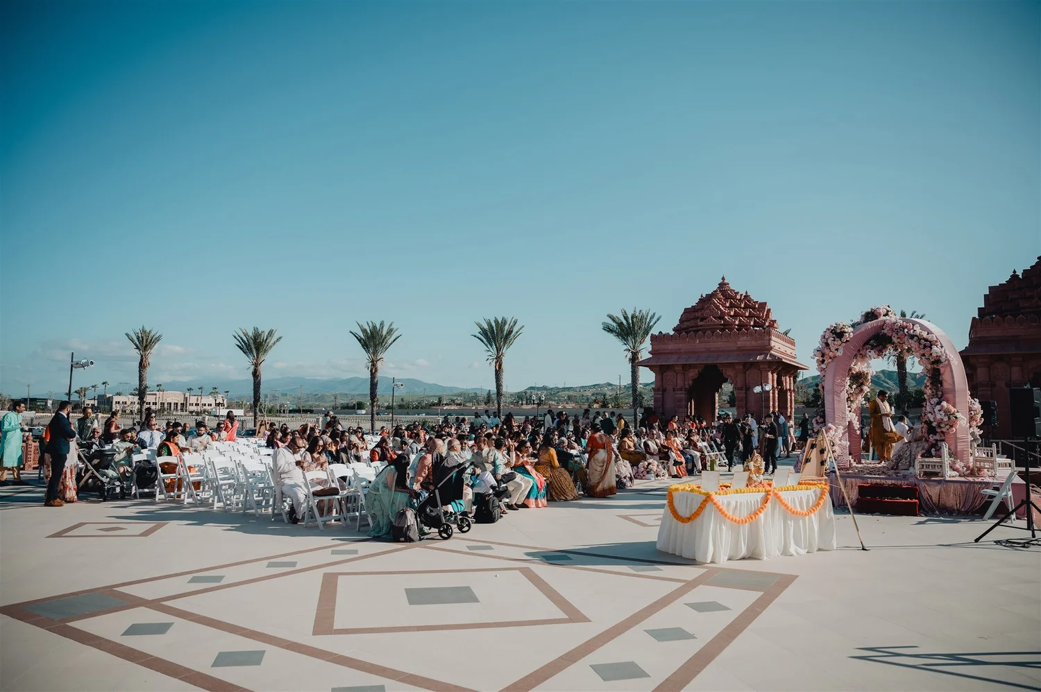 Outdoor floral mandap on the plaza with guests seated, BAPS mandir in Chino Hills