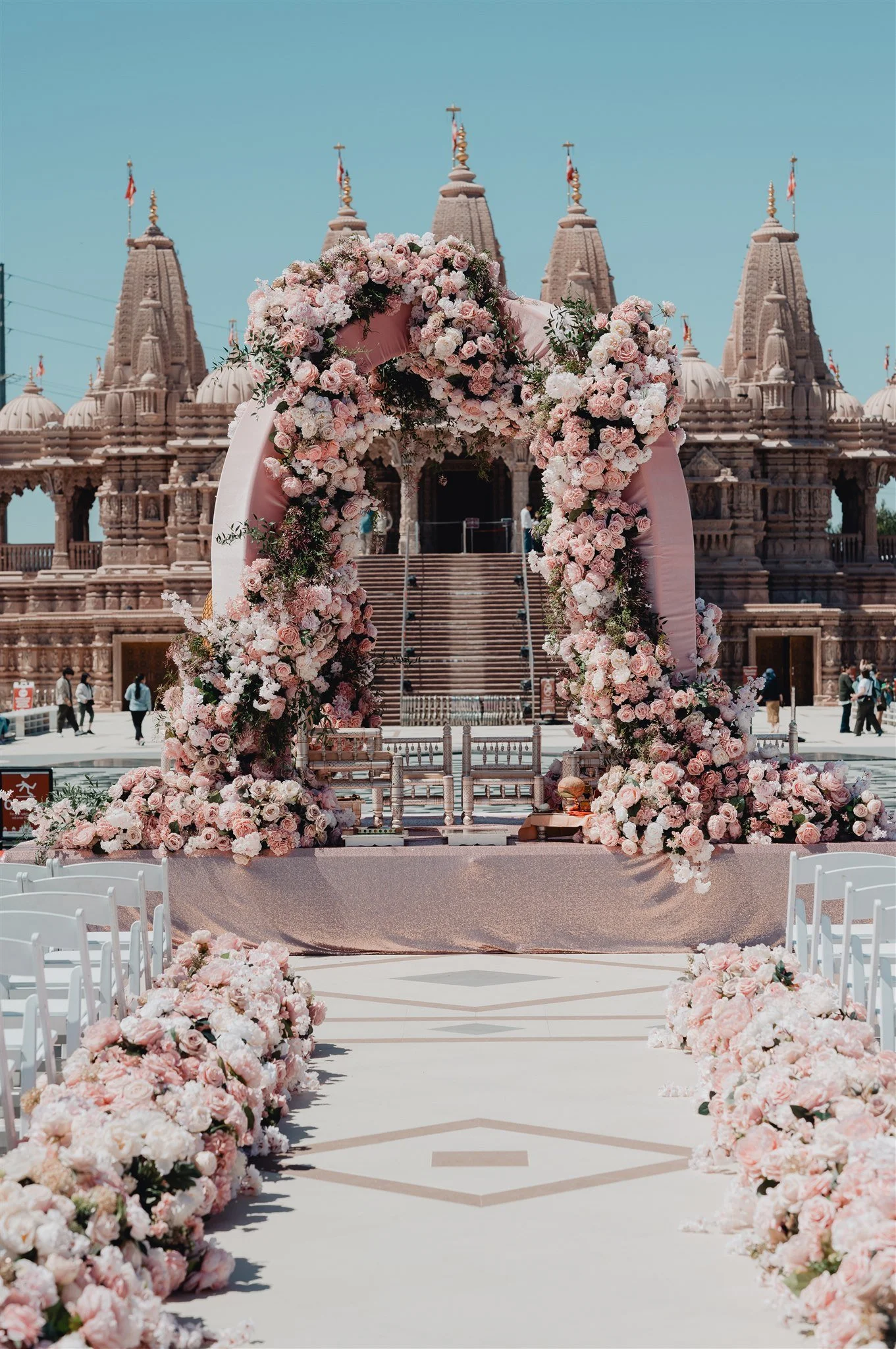Floral mandap framed in pink roses in front of the BAPS Shri Swaminarayan Mandir in Chino Hills