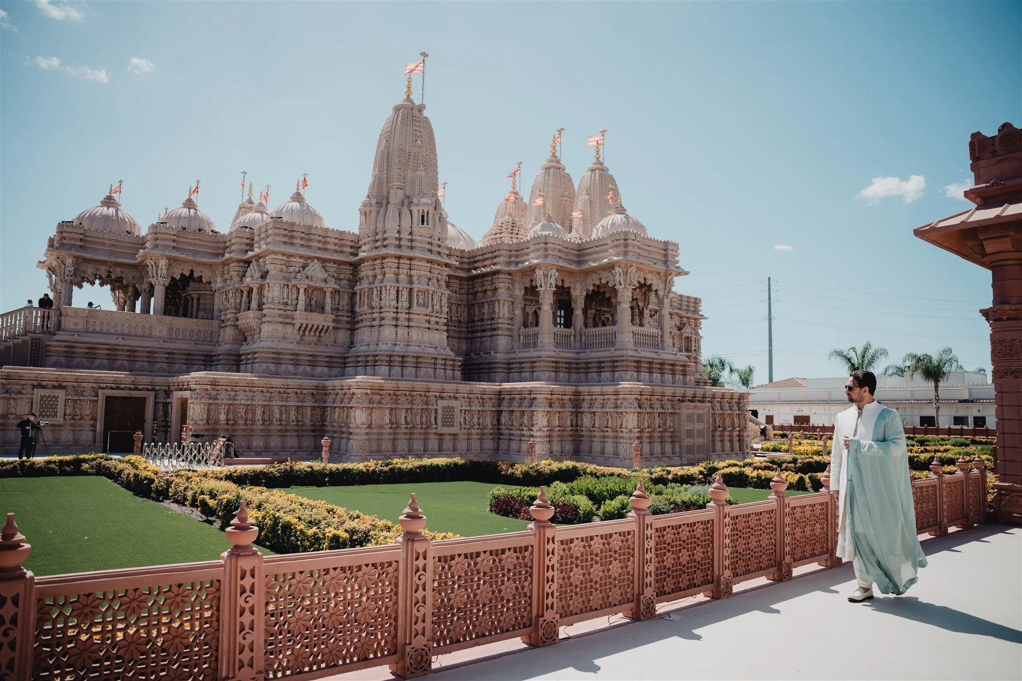 The hand-carved BAPS Shri Swaminarayan Mandir in Chino Hills, with the groom on the sandstone terrace