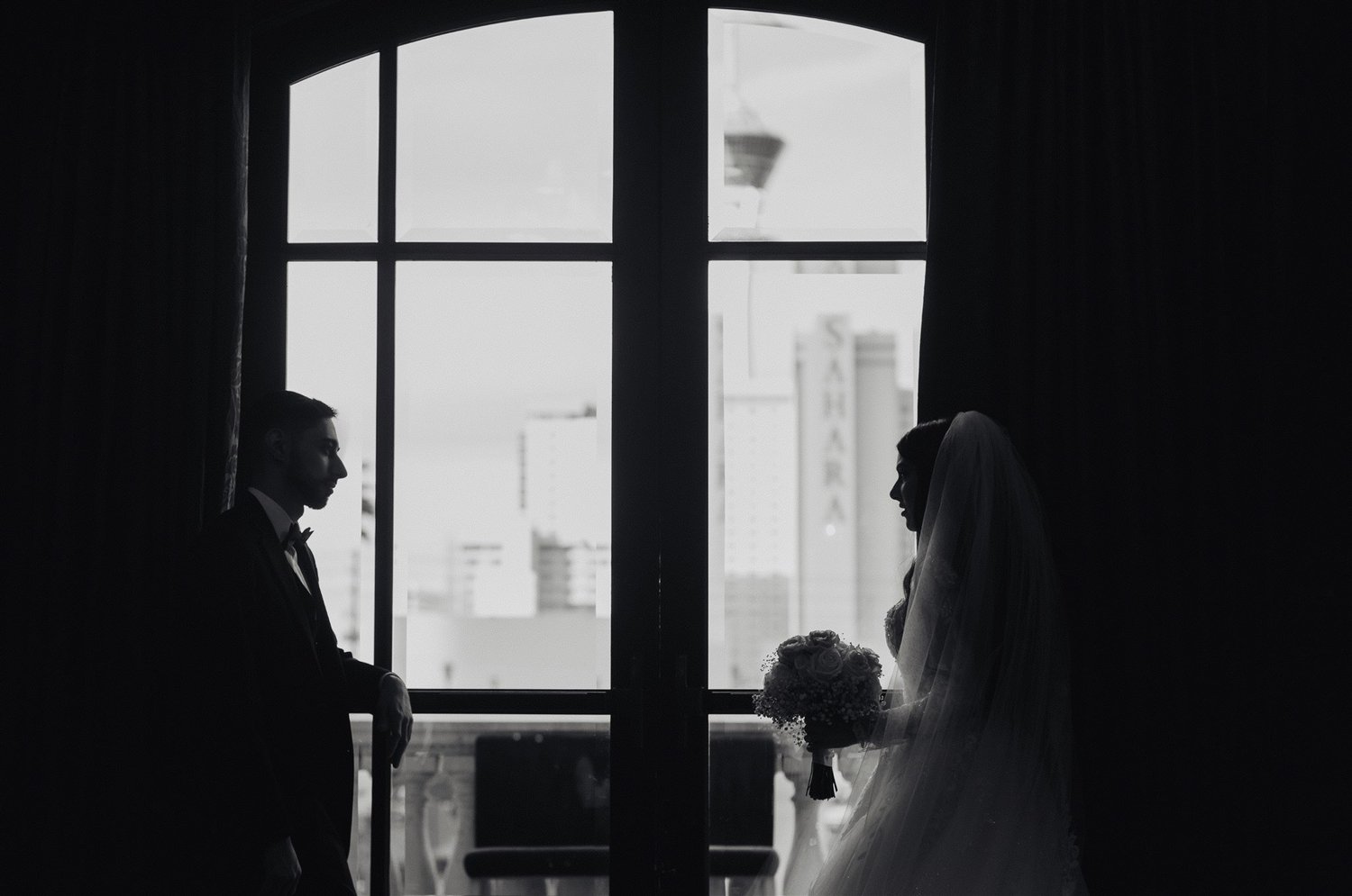 Couple silhouetted against tall windows in a wood-paneled room at The Stirling Club