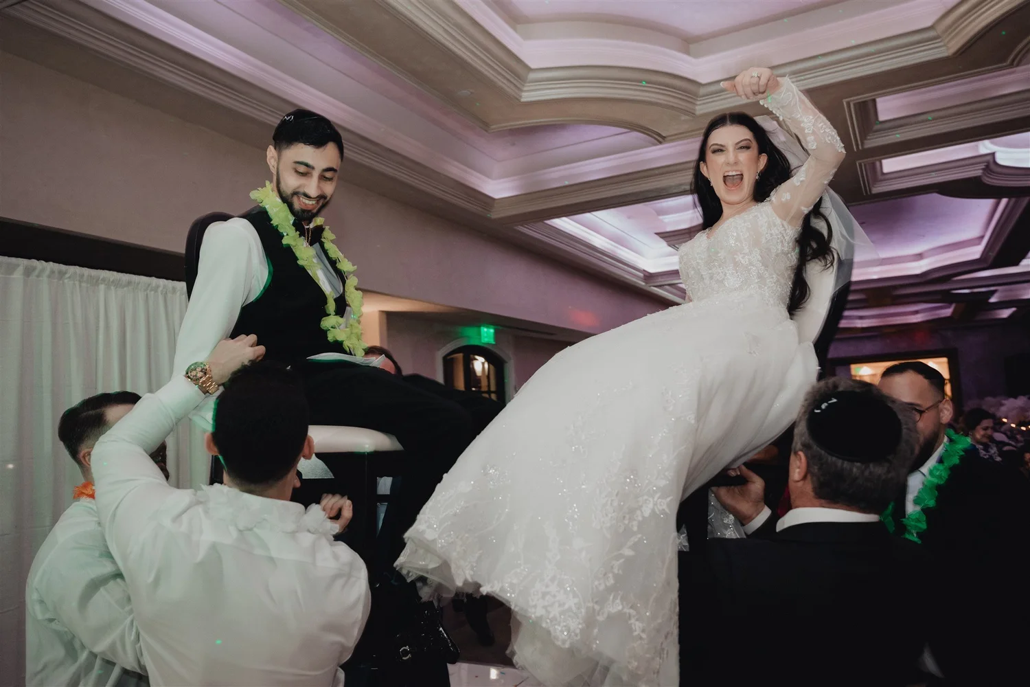 Couple lifted on chairs during the hora at a Stirling Club reception