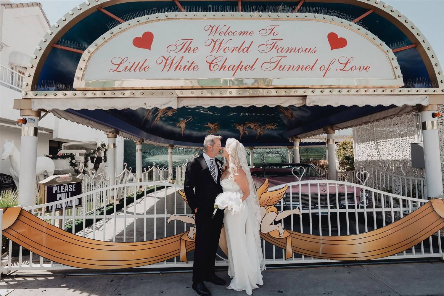 Bride and groom embracing outside A Little White Wedding Chapel's Tunnel of Love, Las Vegas