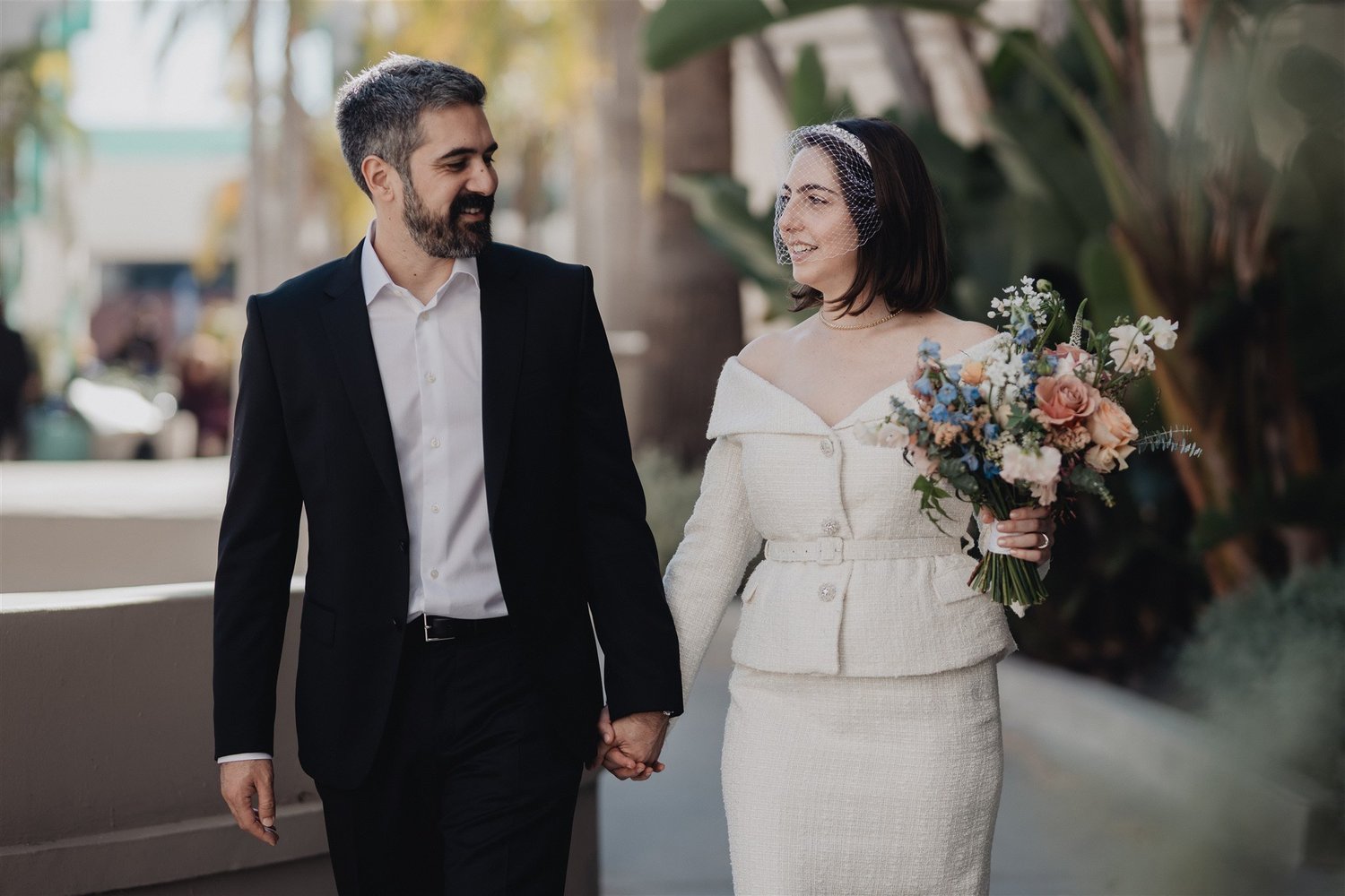 Newlyweds holding a bouquet outside after their Beverly Hills courthouse wedding ceremony