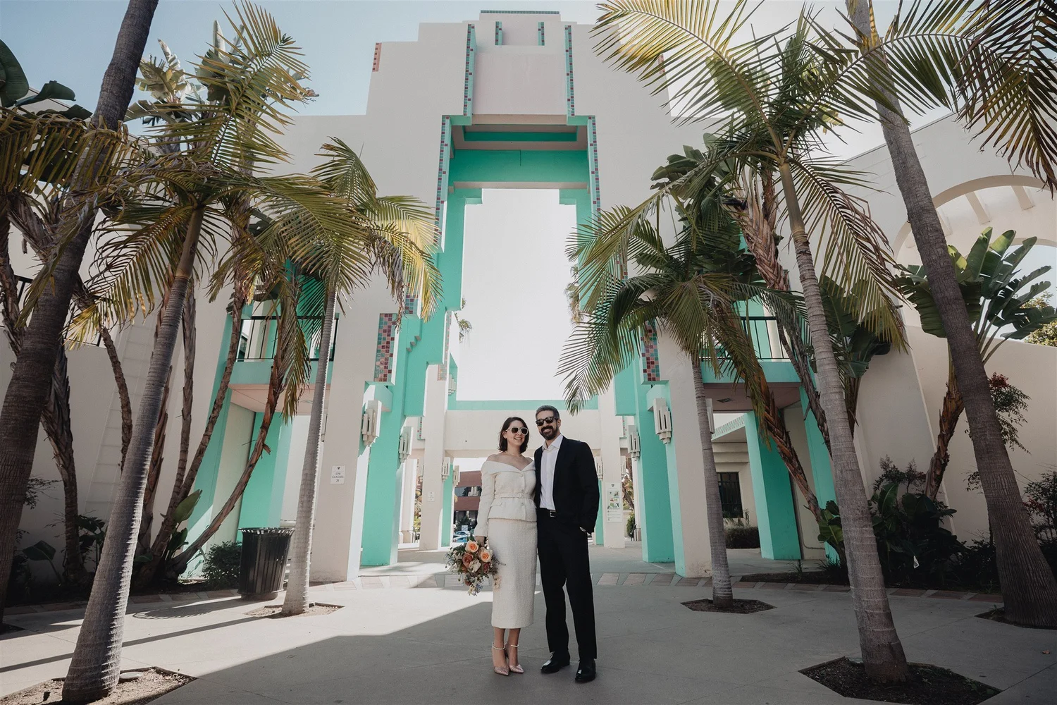 Wedding couple standing beneath the turquoise-tiled arcade at Beverly Hills City Hall after their courthouse ceremony