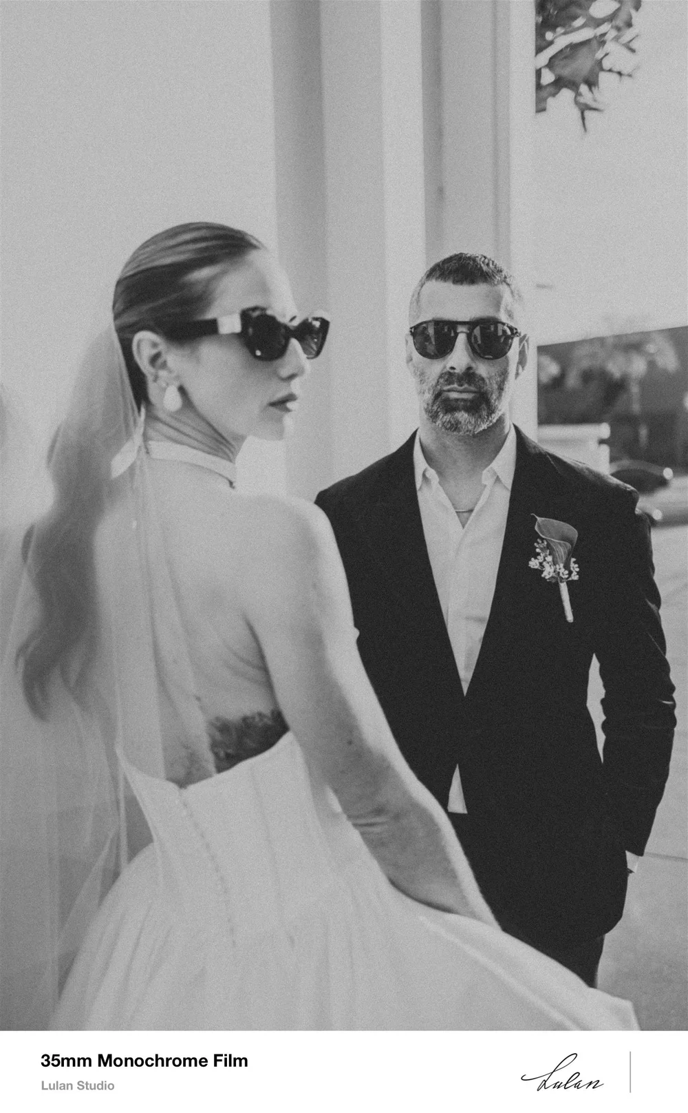 Bride and groom in sunglasses photographed on 35mm black and white film, scanned as a bordered print