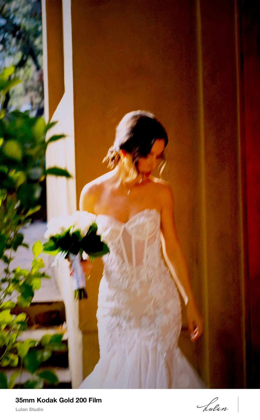 Bride walking in warm light photographed on Kodak Gold 200 film, scanned as a bordered print