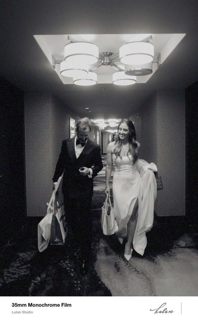 35mm black and white film — bride and groom walking a hotel corridor