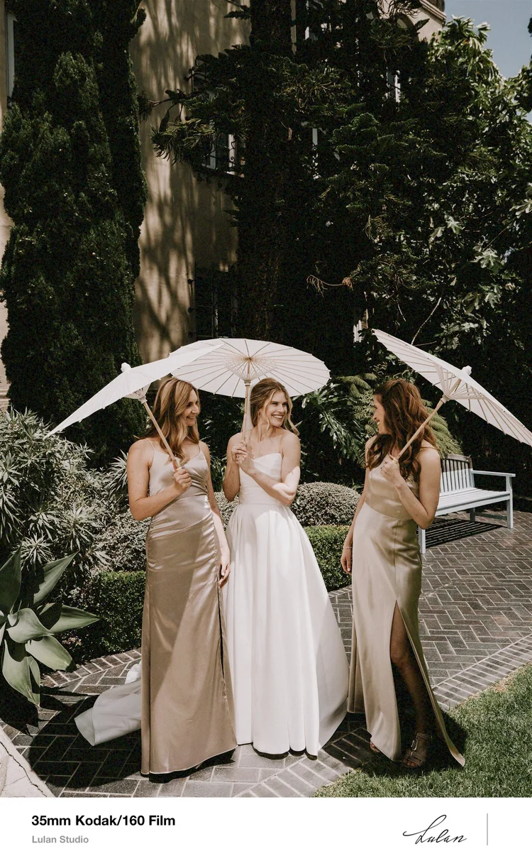35mm Kodak 160 film — bridesmaids holding parasols in a garden before the ceremony
