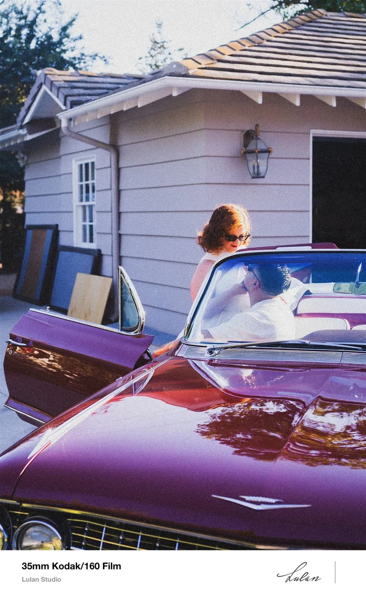 35mm Kodak 160 film — bride stepping out of a classic car outside a white clapboard house