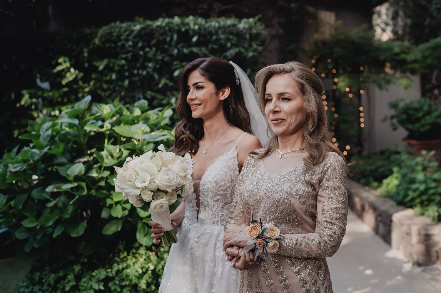 Bride standing with her mother in a garden before walking down the aisle