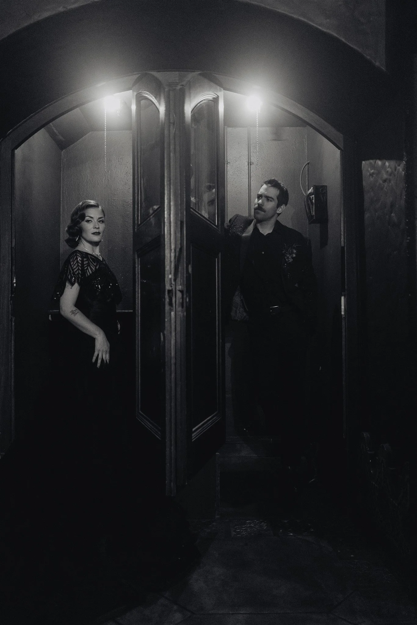 Bride and groom holding hands around a door for a first touch on their wedding day