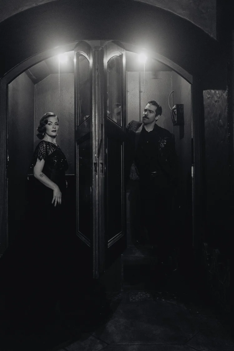 Bride and groom holding hands around a door for a first touch on their wedding day