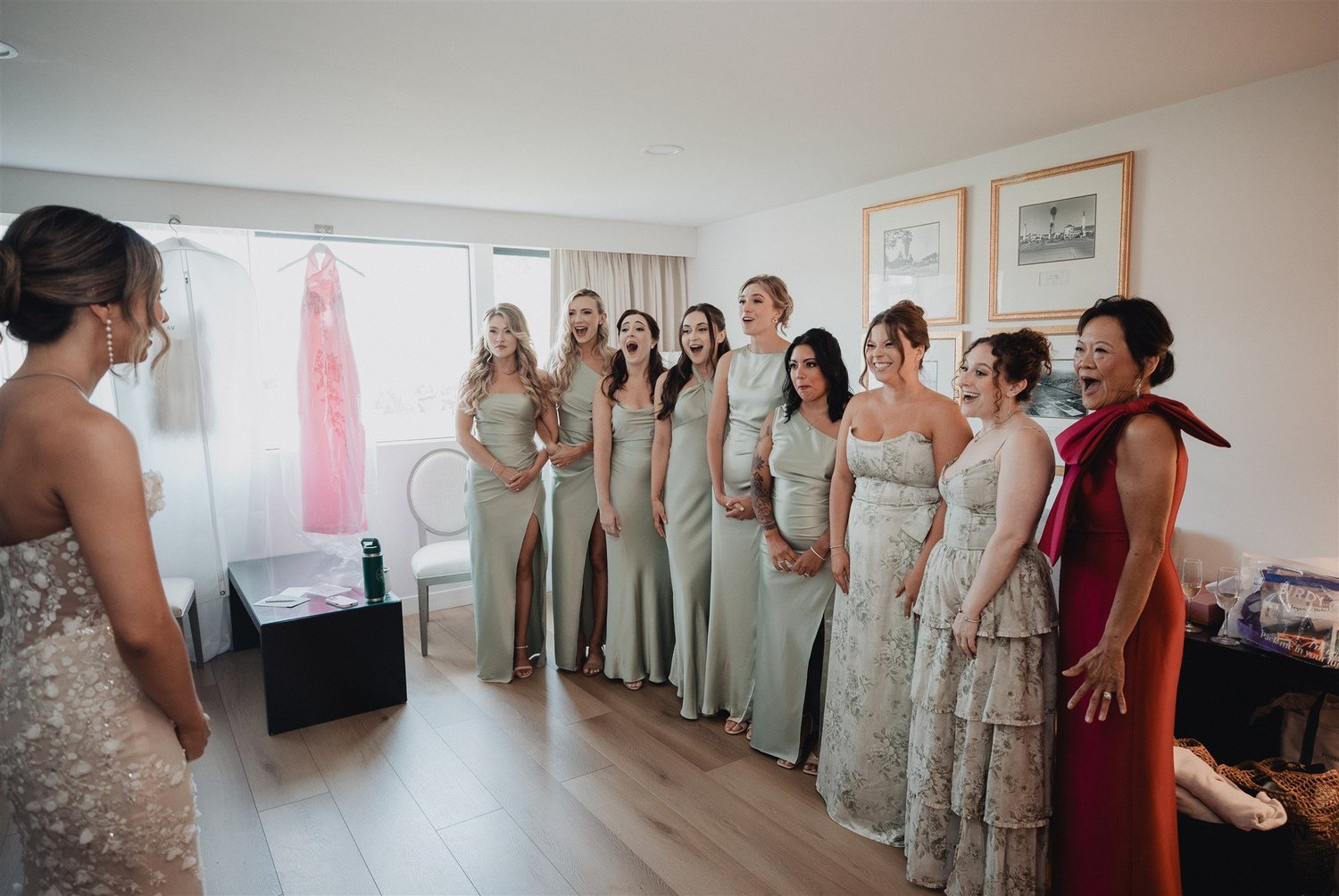 Bridesmaids reacting as they see the bride in her dress for the first time