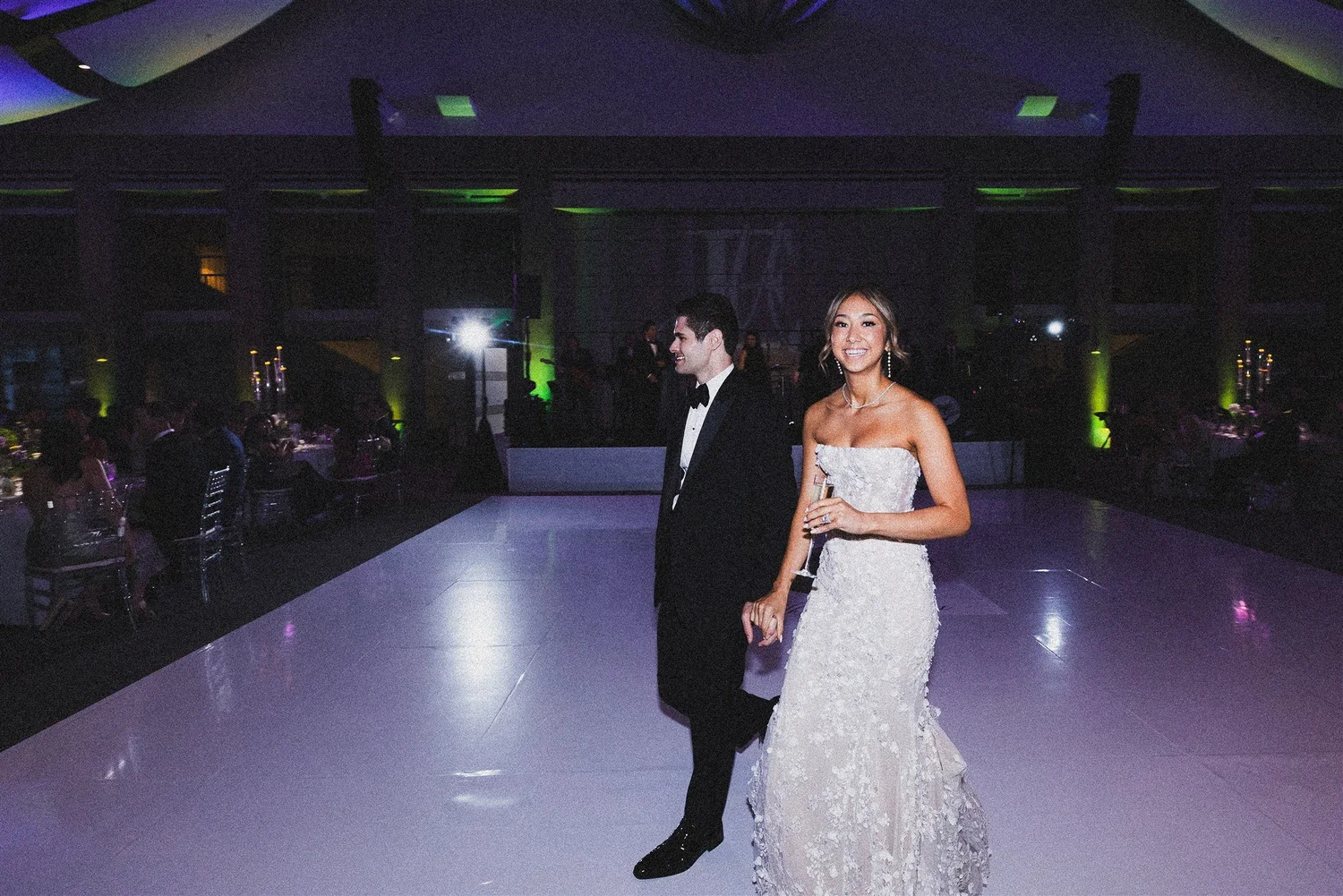 A couple walking the dance floor at their evening reception, photographed and finished the same day