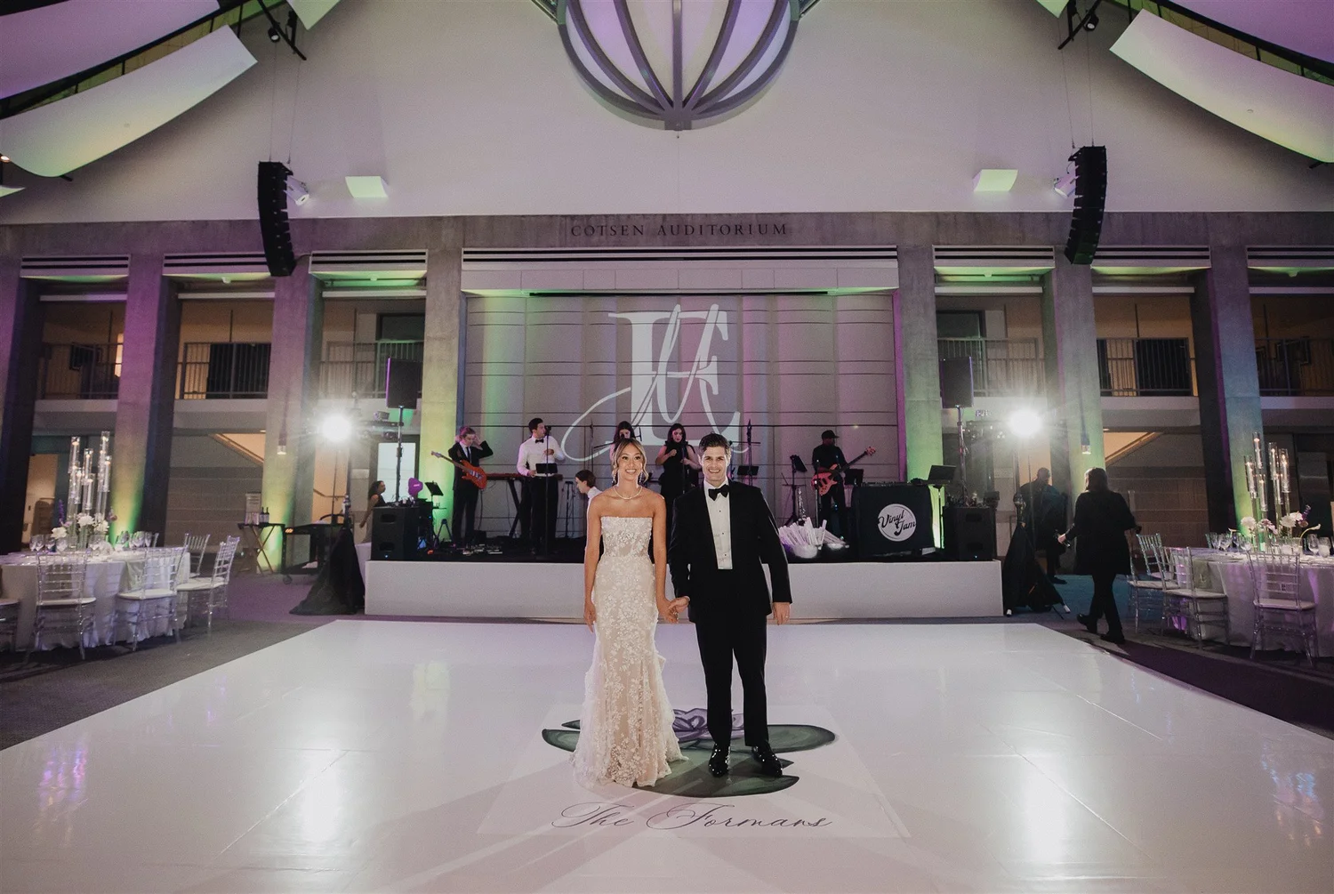 A reception room lit for the evening, where same-day photographs are shown on the big screen