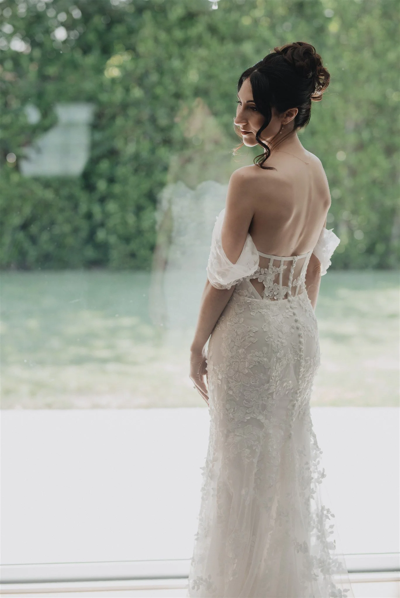 Back of the bride’s corset gown on the lawn before the ceremony
