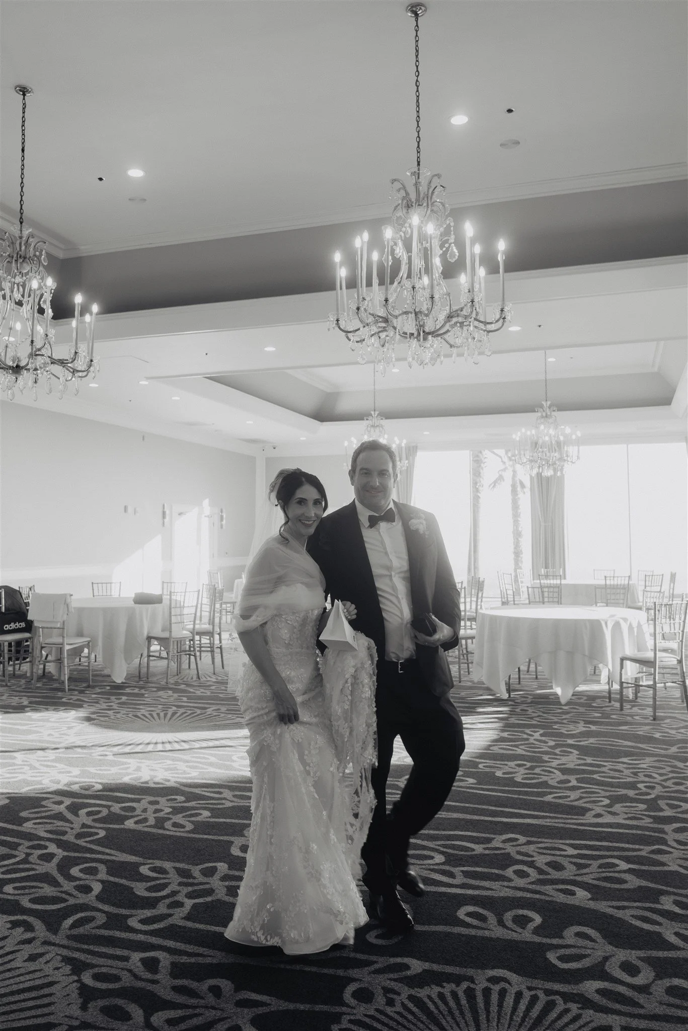 Bride and groom in a chandeliered ballroom before the reception