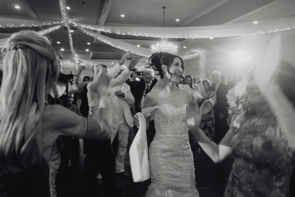 Black and white photo of a packed wedding dance floor late at night