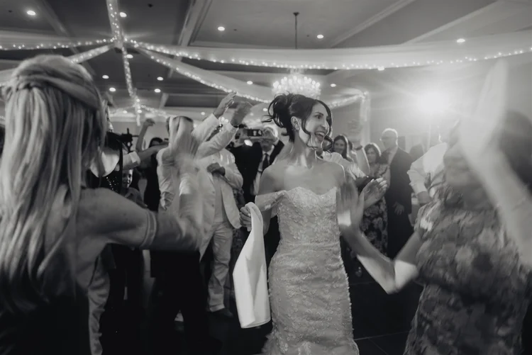 Black and white frame of a packed wedding dance floor late in the evening