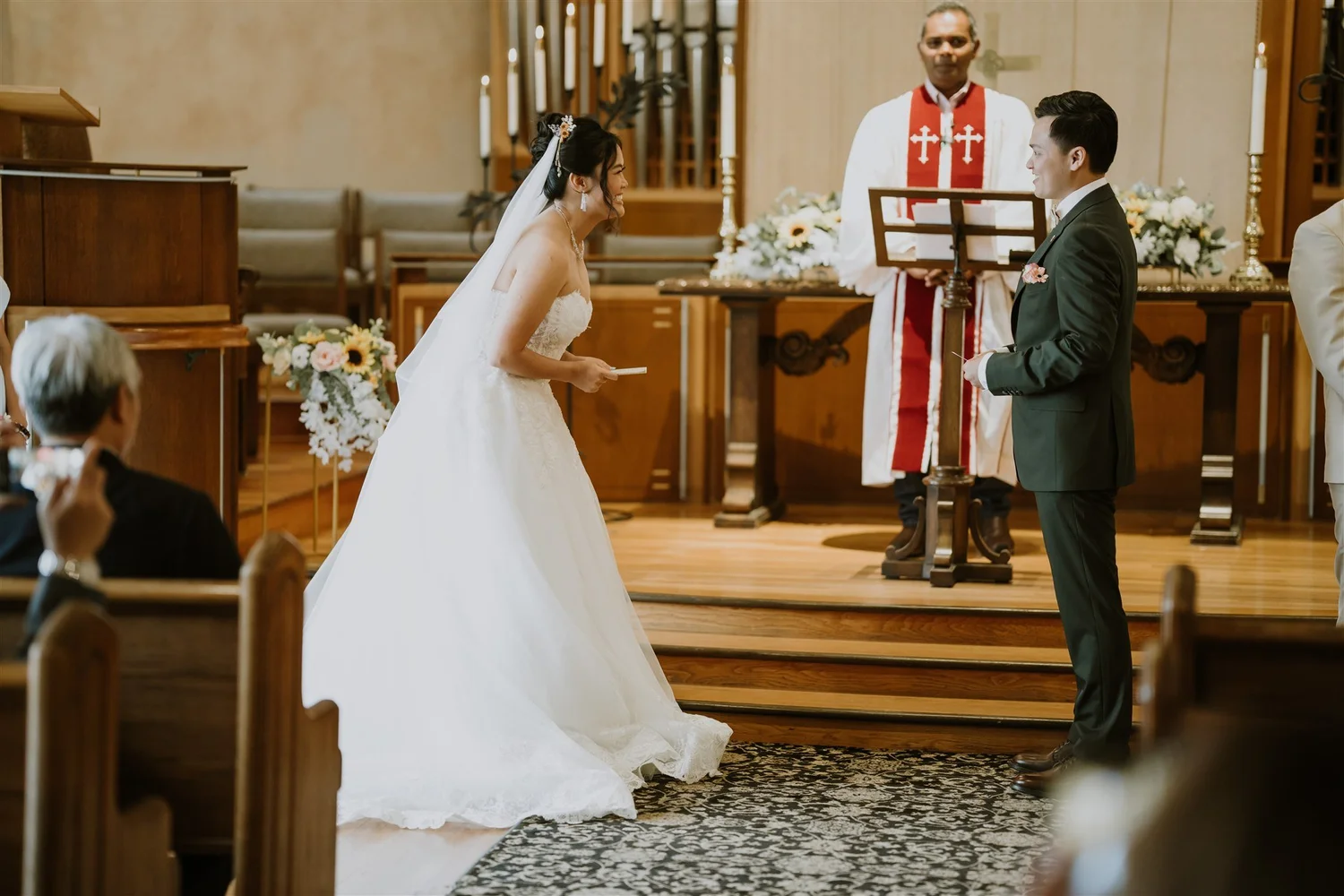 A bride and groom at the altar during their church wedding ceremony the same afternoon