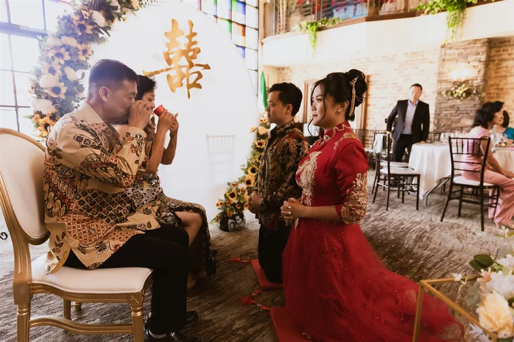 A Chinese tea ceremony served to the parents in front of a double happiness backdrop