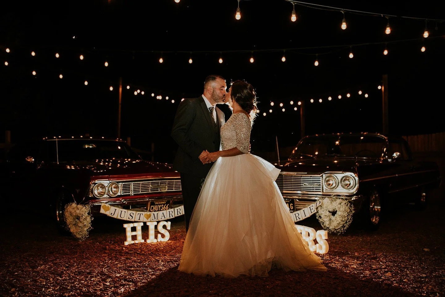 Couple beside a vintage car under string lights at a Beverly Hills wedding