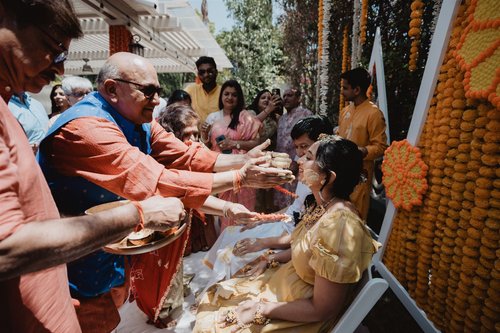 Family applying turmeric to the bride during a Haldi ceremony