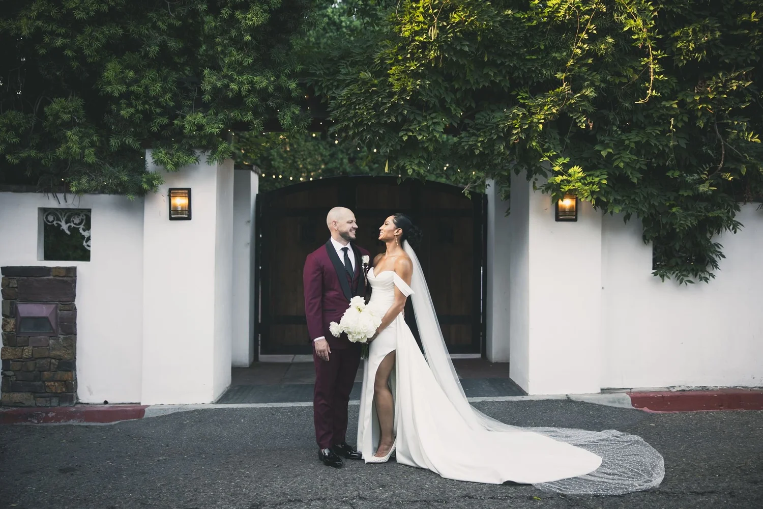 Bride and groom in the white arched doorway at Franciscan Gardens, San Juan Capistrano